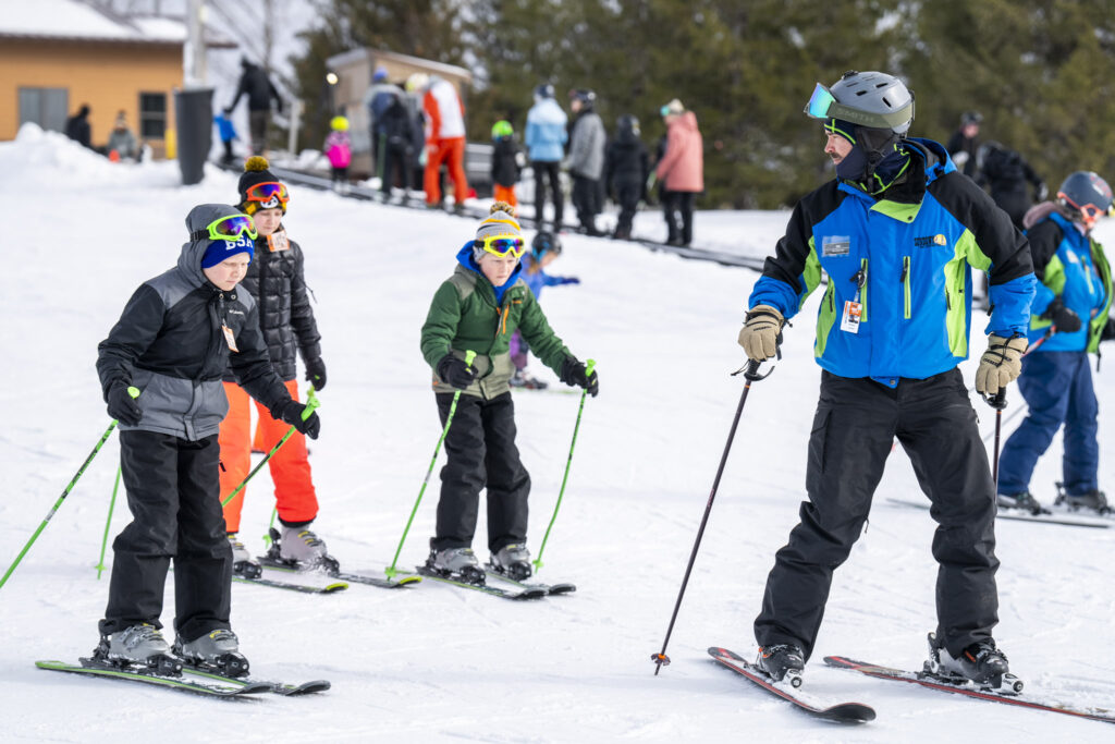 An instructor leading young skiers in a group lesson