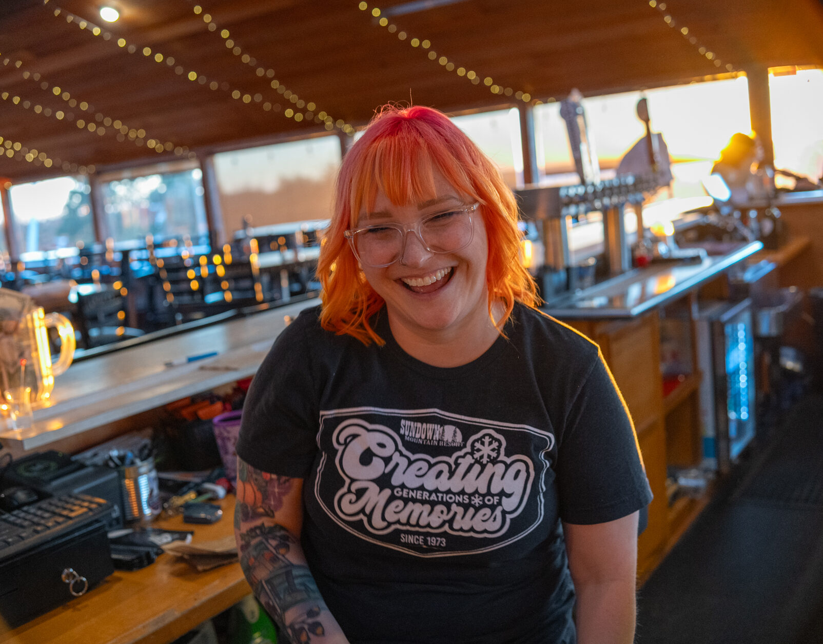 Smiling bartender behind the bar at Tips Up in North Lodge